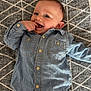 baby, child, denim_shirt, jeans, smiling, happy, lying_down, carpet, patterned, casual_clothing, cute, infant, playful, portrait, indoor, young_child, buttoned_shirt, short_hair, blue_clothing, human