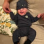 Colson is registered to the contest to win money with this photo: baby, child, clothing, couch, cozy, cute, fabric, floral_pillow, happy, hat, holding_hands, indoor, infant, person, pillow, portrait, seated, smiling, socks, tattooed_hand