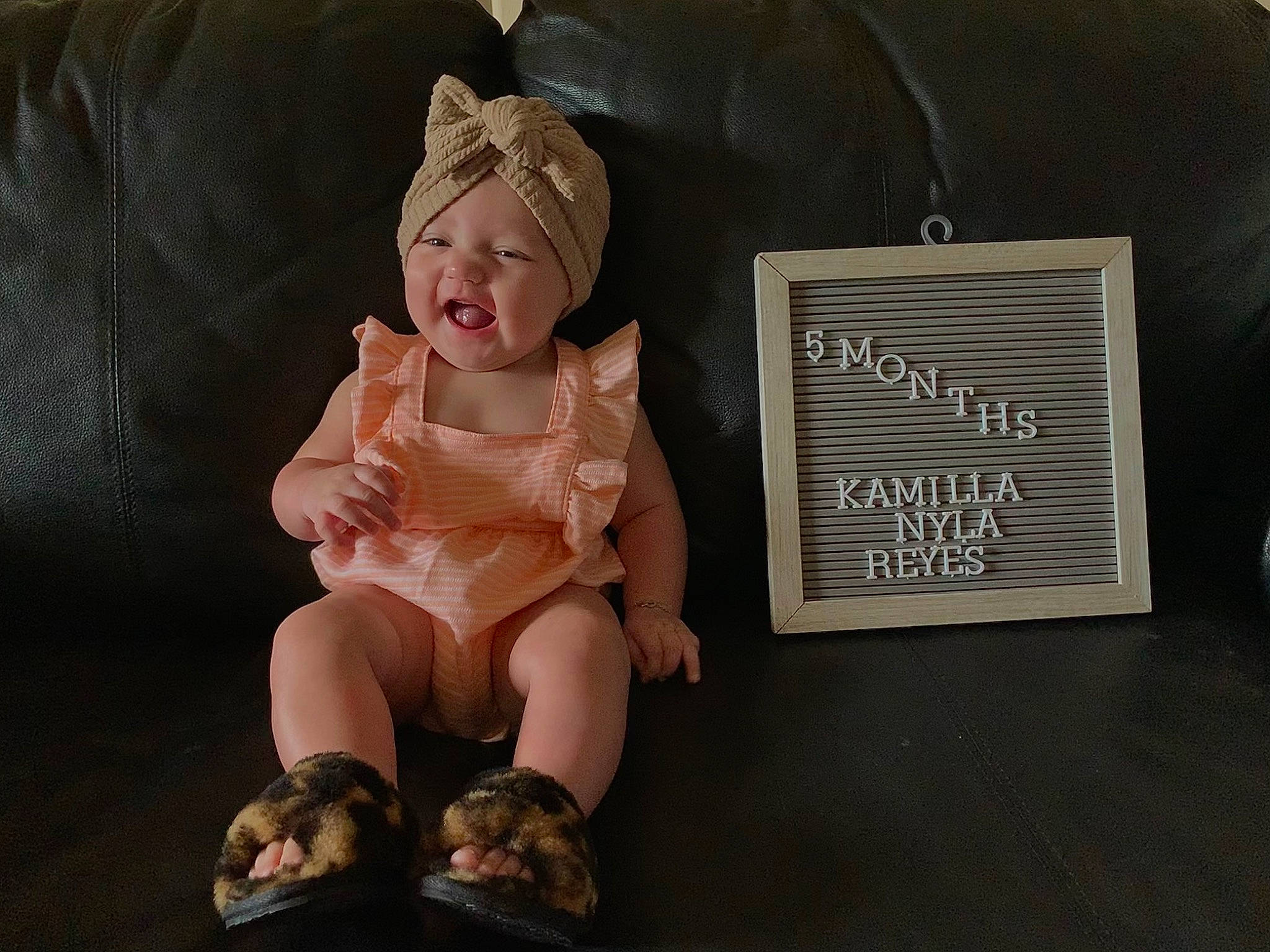 Kamilla is registered to the contest to win money with this photo: baby, baby_toddler_clothing, child, comfort, costume_hat, fashion_accessory, flooring, foot, happy, hat, headwear, human_leg, knee, person, room, sitting, sleeve, sock, sun_hat, thigh