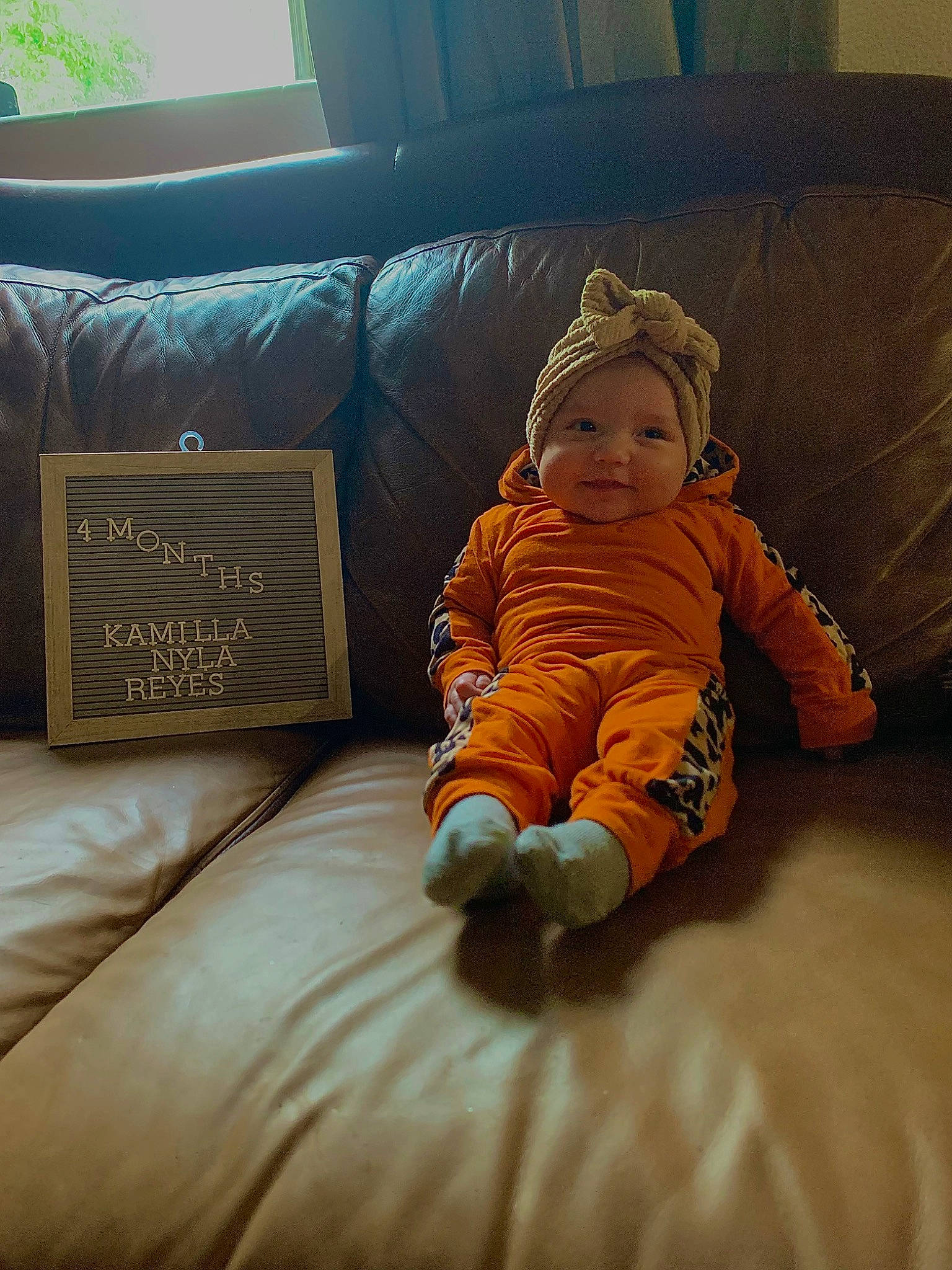 Kamilla joined the competition — help win amazing prizes! baby, baby_toddler_clothing, child, comfort, couch, floor, flooring, hardwood, head, headwear, linens, person, pillow, product, room, sitting, sleeve, sofa_bed, studio_couch, throw_pillow