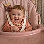 baby, high_chair, smiling, child, infant, pink, face, happy, seated, indoors, clothing, straps, cute, young, person, head, skin, expression, furniture, home