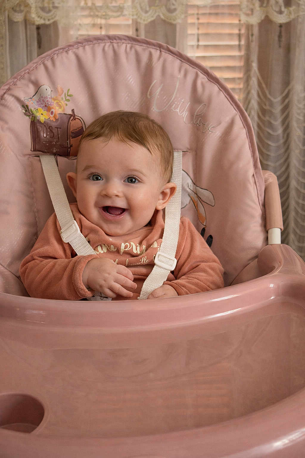 Manel a rejoint le concours — aidez-le/la à gagner de superbes lots ! baby, high_chair, smiling, child, infant, pink, face, happy, seated, indoors, clothing, straps, cute, young, person, head, skin, expression, furniture, home