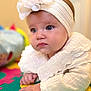 baby, infant, child, headband, flower, white_clothing, play_mat, colorful, hand, face, blue_eyes, indoors, portrait, cute, soft_lighting, closeup, young_child, crawling, expression, texture