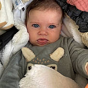 Alba participe au concours pour gagner de l'argent avec cette photo : baby, child, face, blue_eyes, tongue_out, blanket, cozy, clothing, soft_texture, fur, cute, infant, warm, apparel, portrait, closeup, expression, indoor, person, adorable