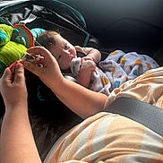 Ian joined the competition — help win amazing prizes! baby, child, car_seat, blanket, toy, child_hands, seatbelt, striped_shirt, window, interior, curious, soft_light, car, infant, child_playing, colorful_blanket, child_in_car, family, travel, casual