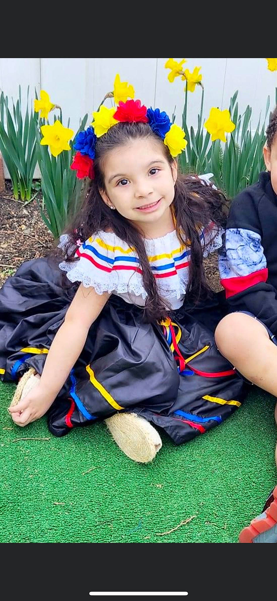 Emmy is registered to the contest to win money with this photo: botany, child, electric_blue, event, flower, fun, grass, hairstyle, happy, joy, leisure, person, plant, shoe, sitting, smile, sneakers, sock, summer, thigh