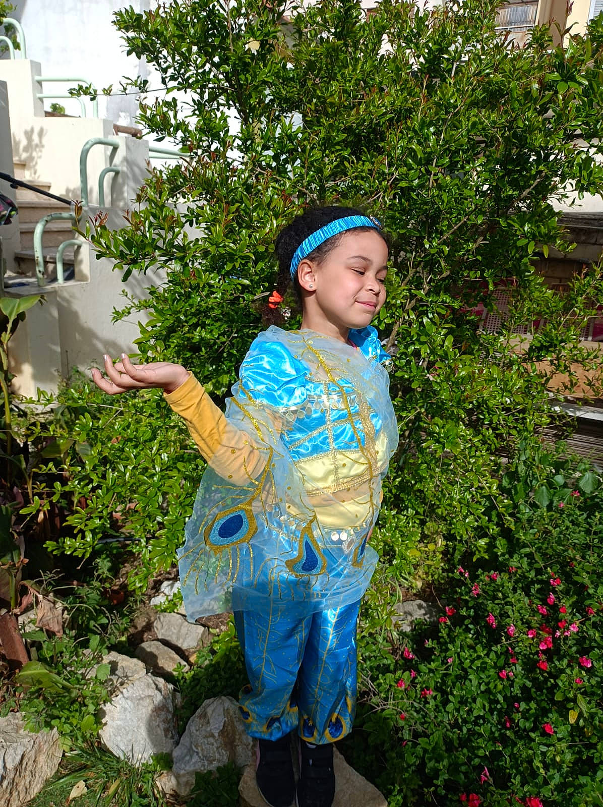 Maya participe au concours pour gagner de l'argent avec cette photo : botany, child, costume, electric_blue, event, flower, fun, garden, grass, happy, headwear, joy, leisure, people_in_nature, person, plant, sandal, shrub, soil, toddler