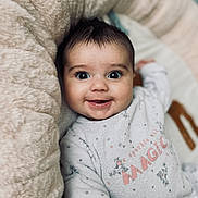 Mia a rejoint le concours — aidez-le/la à gagner de superbes lots ! baby, smiling, infant, face, eyes, clothing, soft, cushion, cozy, cute, portrait, child, happy, indoors, sleepwear, expression, young, adorable, warm, comfort