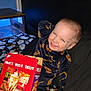 Ryder is registered to the contest to win money with this photo: bed, blanket, cheez_it_box, child, cozy, cute, dark_wall, food_package, fun, ghost_pattern, happy, indoor, pajamas, person, playful, relaxed, smiling, snack, table, toy