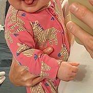 Remii joined the competition — help win amazing prizes! baby, child, smiling, tongue_out, pink_onesie, zebra_pattern, person_holding, indoor, selfie, hand, face, cute, happy, infant, clothing, jeans, white_shirt, bedroom, adult, portrait