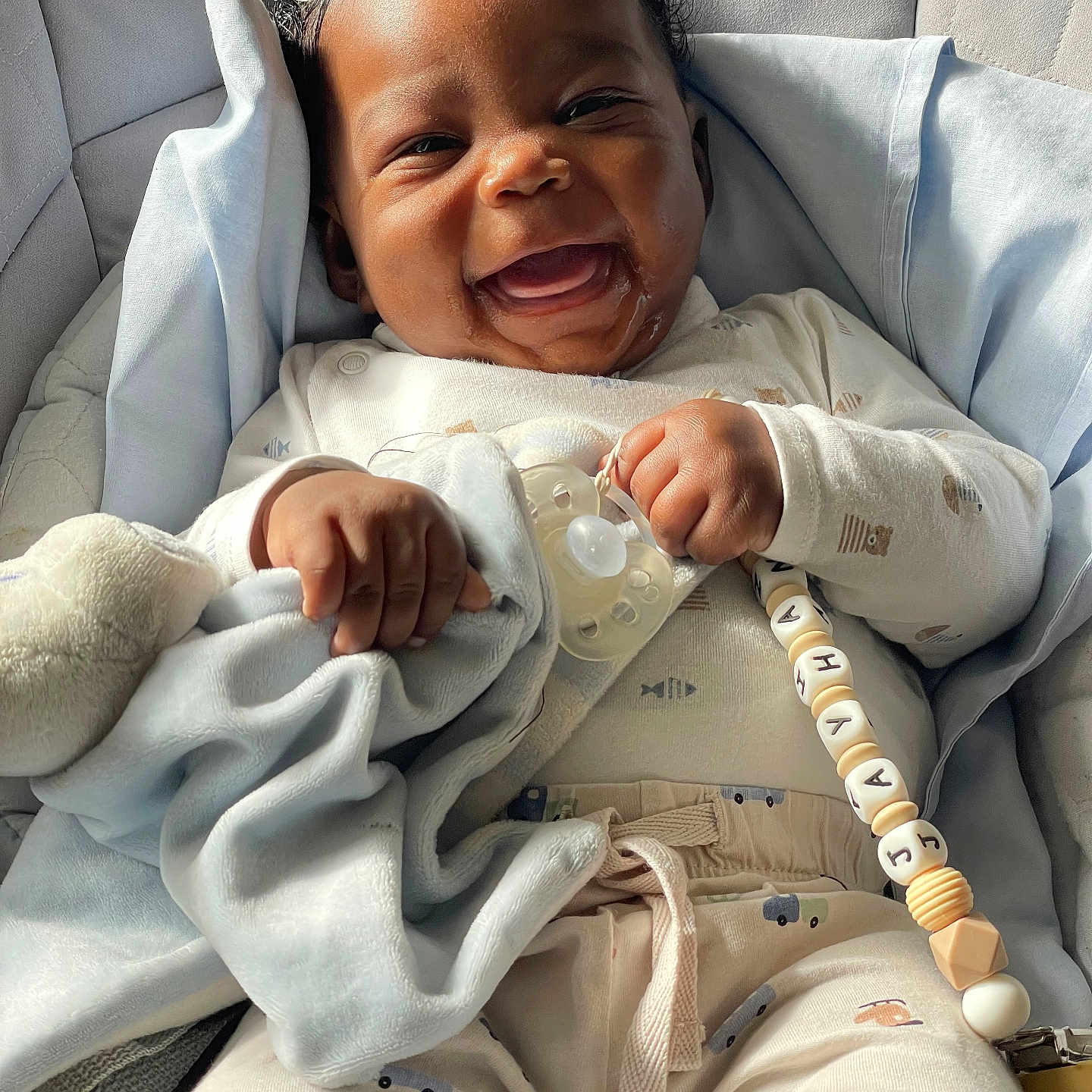 Jayhan a rejoint le concours — aidez-le/la à gagner de superbes lots ! baby, beads, blanket, child, clothing, comfort, cozy, cute, face, hand, happy, indoors, infant, light, pacifier, portrait, relaxing, seat, smiling, soft_toy