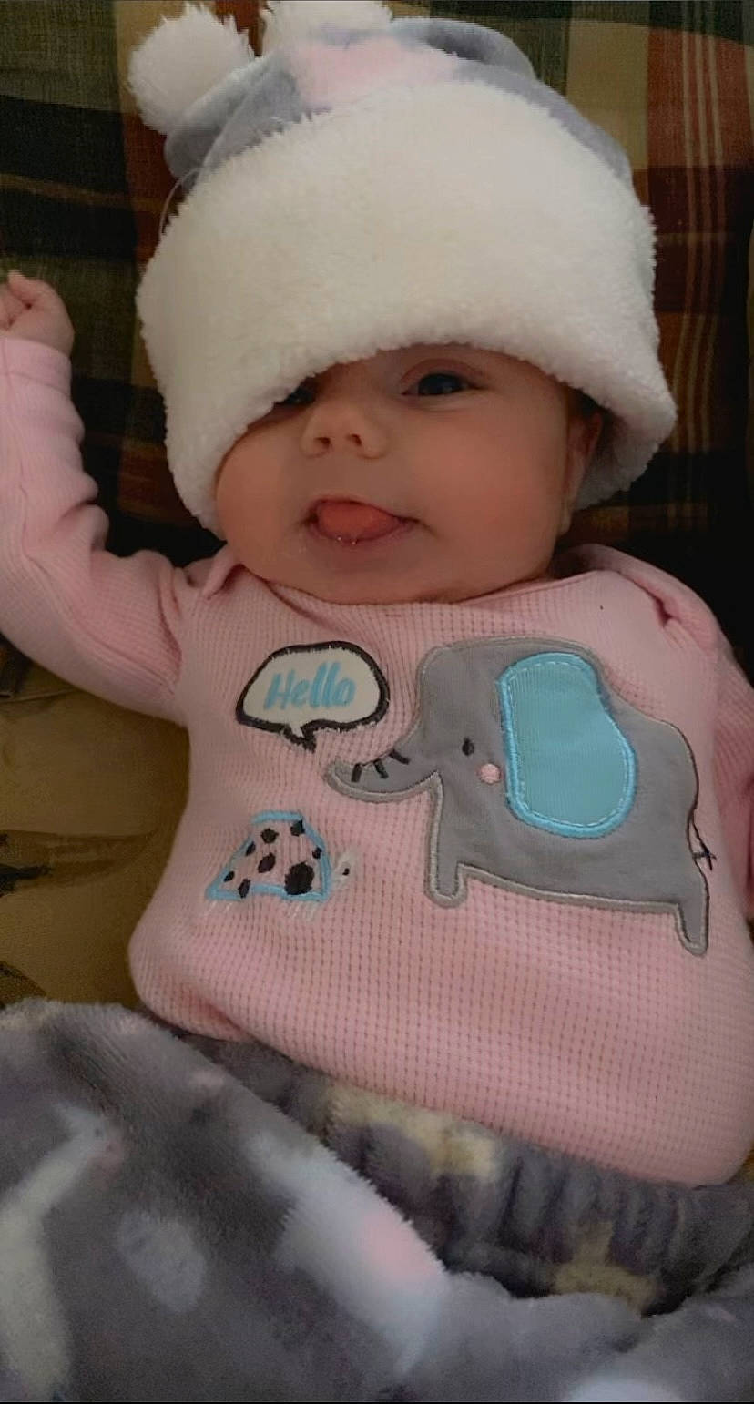 Ellie is registered to the contest to win money with this photo: baby, baby_products, baby_toddler_clothing, beanie, cap, cheek, child, chin, eye, face, happy, head, headwear, human_body, knit_cap, person, pink, skin, sleeve, smile