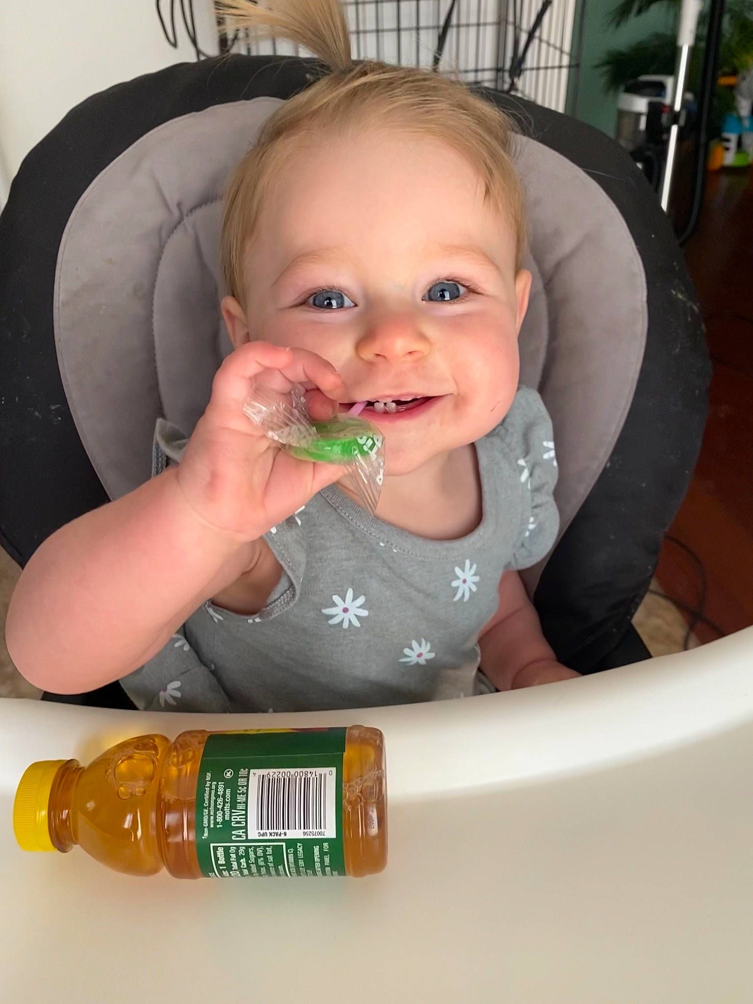 Rowan is registered to the contest to win money with this photo: baby, baby_playing_with_food, baby_toddler_clothing, bottle, chair, cheek, child, facial_expression, finger, food_craving, green, hand, iris, mouth, nose, person, product, skin, smile, thumb