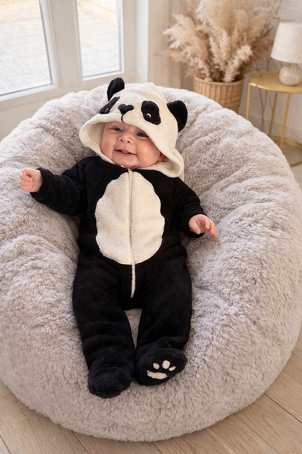 Alix participe au concours pour gagner de l'argent avec cette photo : baby, infant, plush, panda_costume, onesie, hood, smile, beanbag, cozy, nursery, indoor, sitting, cute, chubby_cheeks, soft, blanket_like, lamp, pampas_grass, hardwood_floor, portrait