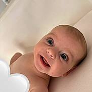 Novah-Seren is registered to the contest to win money with this photo: baby, smiling, face, blue_eyes, skin, head, infant, lying_down, happy, child, closeup, human, portrait, cute, expression, naked, newborn, soft_background, indoors, heart_shape