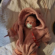 Jada joined the competition — help win amazing prizes! baby, blanket, child, comfort, cute, face, hooded_jacket, indoor, infant, lying_down, newborn, pacifier, person, pink_clothing, portrait, sleepwear, soft_texture, toddler, warm_clothing, zipped_jacket