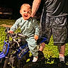 Wyatt joined the competition — help win amazing prizes! child, toddler, dirt_bike, blue, smiling, happy, night, outdoor, grass, tattoo, adult, shorts, socks, shoes, person, toy_vehicle, casual_clothing, joyful, protective, family