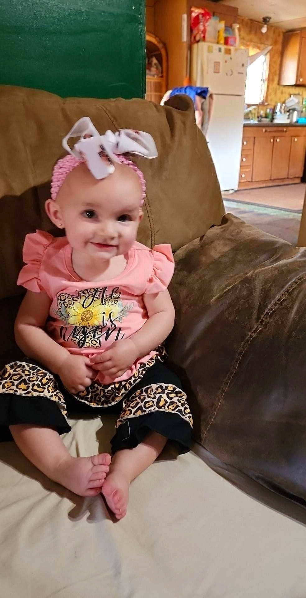 Kinsley is registered to the contest to win money with this photo: baby, baby_toddler_clothing, cabinetry, chest_of_drawers, child, comfort, couch, cupboard, drawer, event, fun, happy, human_leg, iris, joy, lap, person, pink, sitting, skin
