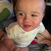 Zayden is registered to the contest to win money with this photo: baby, child, smiling, onesie, colorful, face, close_up, candid, indoor, person, cute, happy, skin, expression, infant, playful, young_child, sitting, holding_hands, soft_light