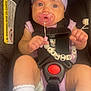 accessory, baby, beads, car_seat, child, closeup, clothing, cute, headband, indoor, infant, pacifier, person, pink, safety, seatbelt, sitting, socks, toy, young_child
