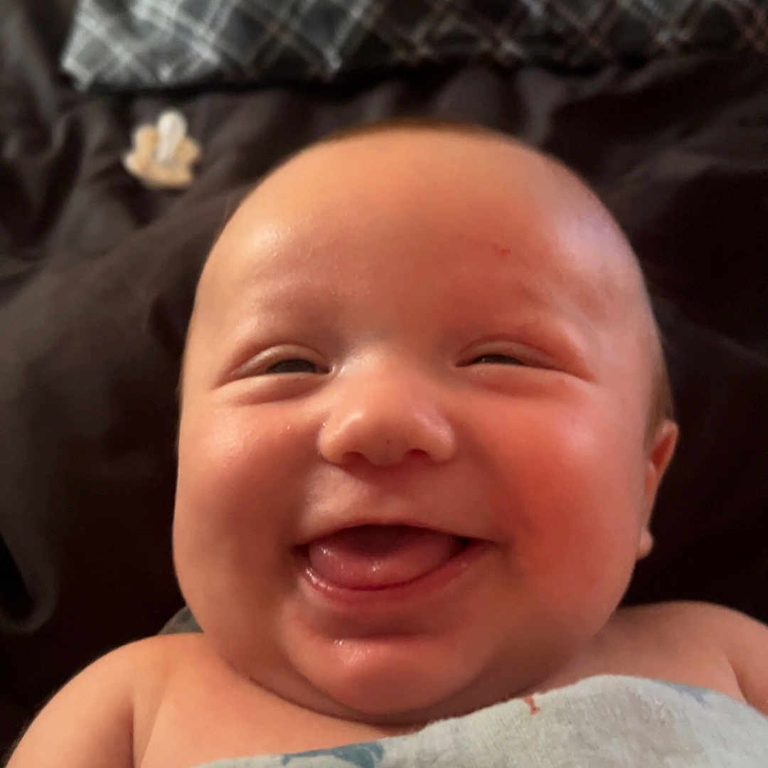 Xavior joined the competition — help win amazing prizes! baby, blanket, cheeks, child, closeup, cute, expression, face, happy, indoors, infant, joyful, lying_down, newborn, portrait, skin, smiling, soft_light, tongue_out, wrapped