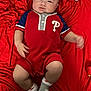 baby, infant, red_blanket, romper, socks, pacifier, toy, carpet, lying_down, child, person, cute, indoor, clothing, footwear, head, face, skin, hand, legs