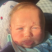 Xavior is registered to the contest to win money with this photo: baby, infant, face, tongue, sunlight, blanket, bib, clothing, expression, indoors, closeup, skin, head, person, cute, young, child, soft, warm, comfort