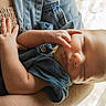 baby, sleeping, arm, hand, denim, clothing, person, portrait, closeup, skin, infant, newborn, soft_light, indoor, window, fabric, peaceful, cute, tiny_fingers, resting