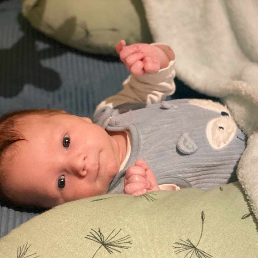 Liam participe au concours pour gagner de l'argent avec cette photo : baby, bed, blanket, bodypart, clothing, cushion, face, finger, furniture, hand, happy, head, newborn, pants, person, photography, portrait, quilt, sleeve, smile