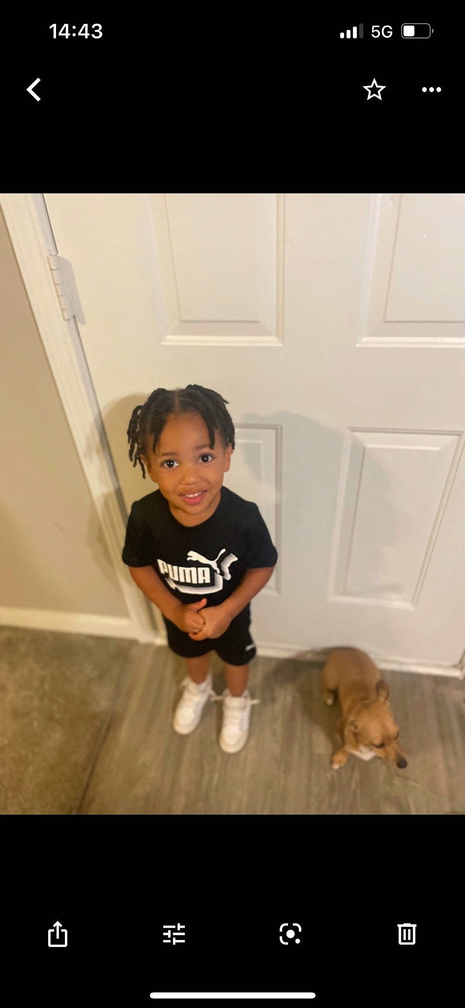 Aspen is registered to the contest to win money with this photo: baby_toddler_clothing, carnivore, companion_dog, dog, dog_breed, door, floor, flooring, happy, hardwood, human_leg, joy, knee, laminate_flooring, leg, person, shorts, sleeve, smile, t_shirt