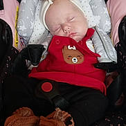 Lilly is registered to the contest to win money with this photo: baby, sleeping, car_seat, headband, red_clothing, reindeer_patch, knitted_booties, cozy, child, infant, cute, star_pattern, seatbelt, comfort, portrait, indoors, peaceful, wearing, person, closeup