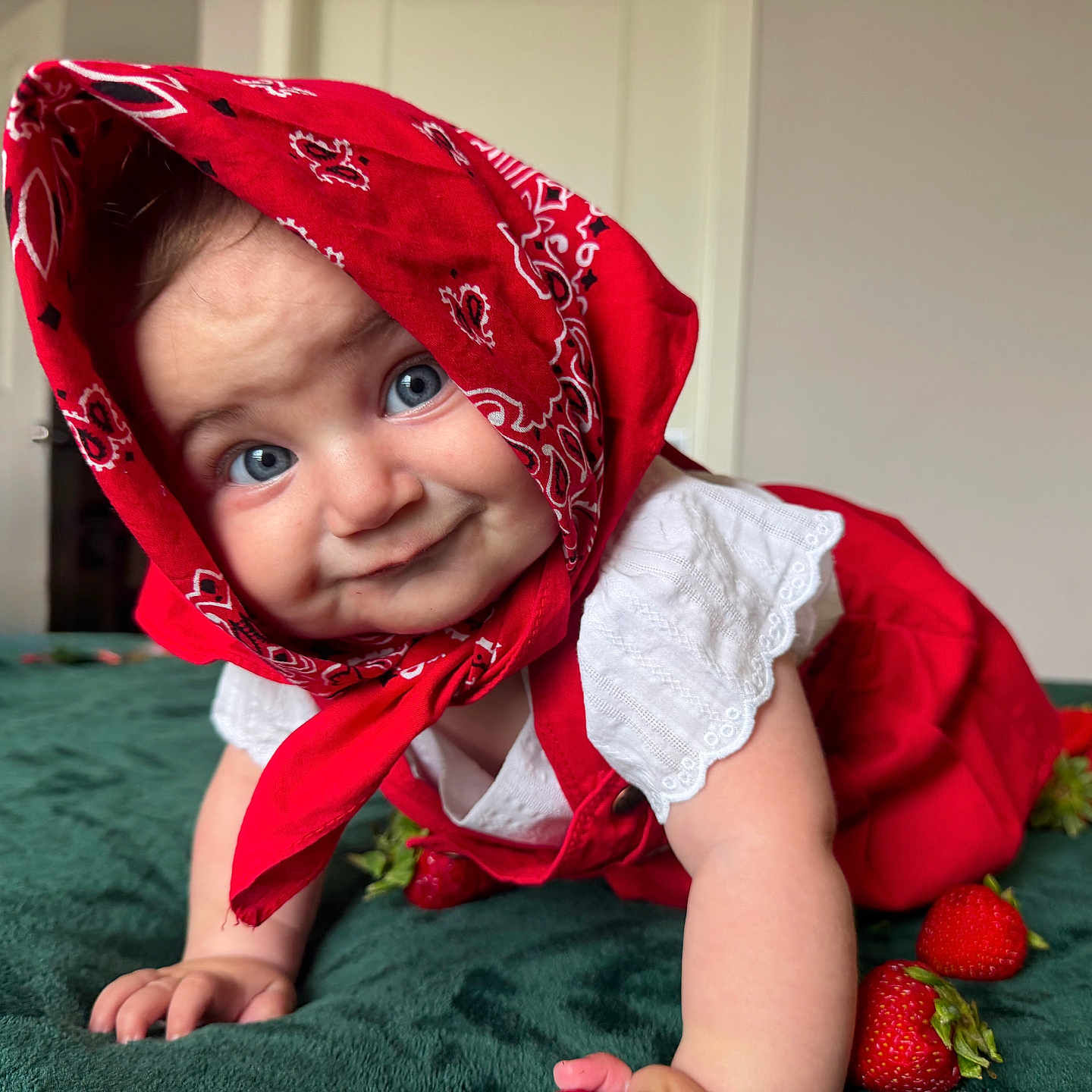 Serli joined the competition — help win amazing prizes! baby, child, face, blue_eyes, red_bandana, red_clothing, crawling, strawberries, green_surface, indoors, cute, smile, white_shirt, infant, headscarf, playful, portrait, close_up, person, happy