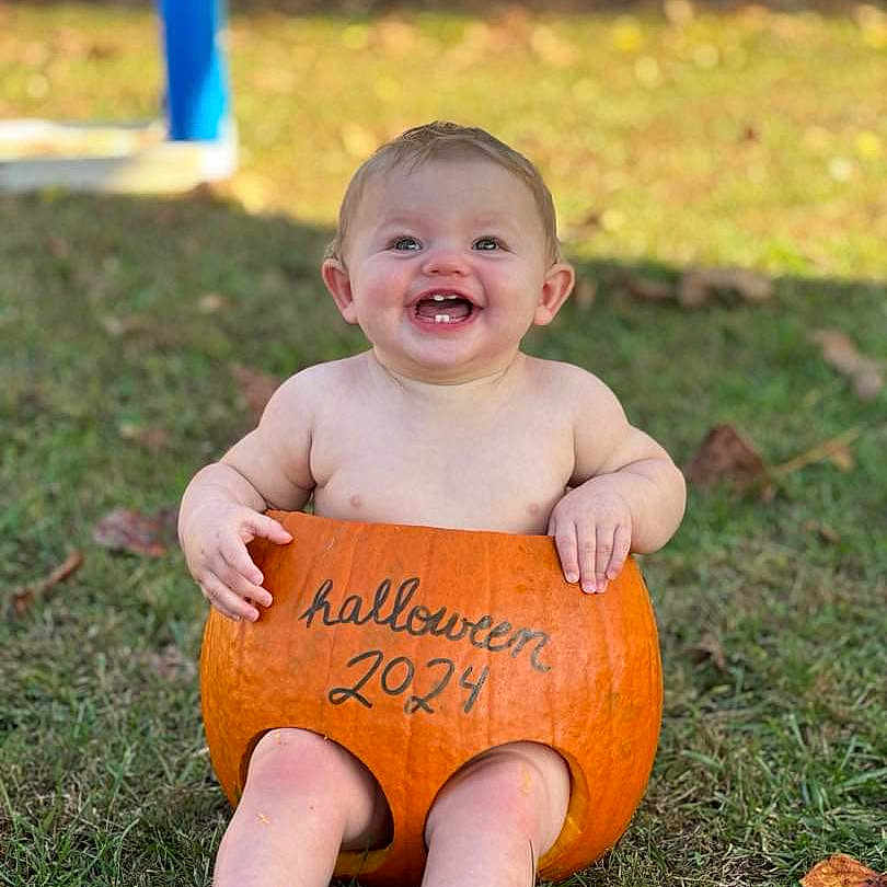Karleigh joined the competition — help win amazing prizes! baby, ball, clothing, face, food, football, grass, happy, head, outdoors, person, photography, plant, portrait, pottedplant, produce, shorts, sitting, squash, vegetable