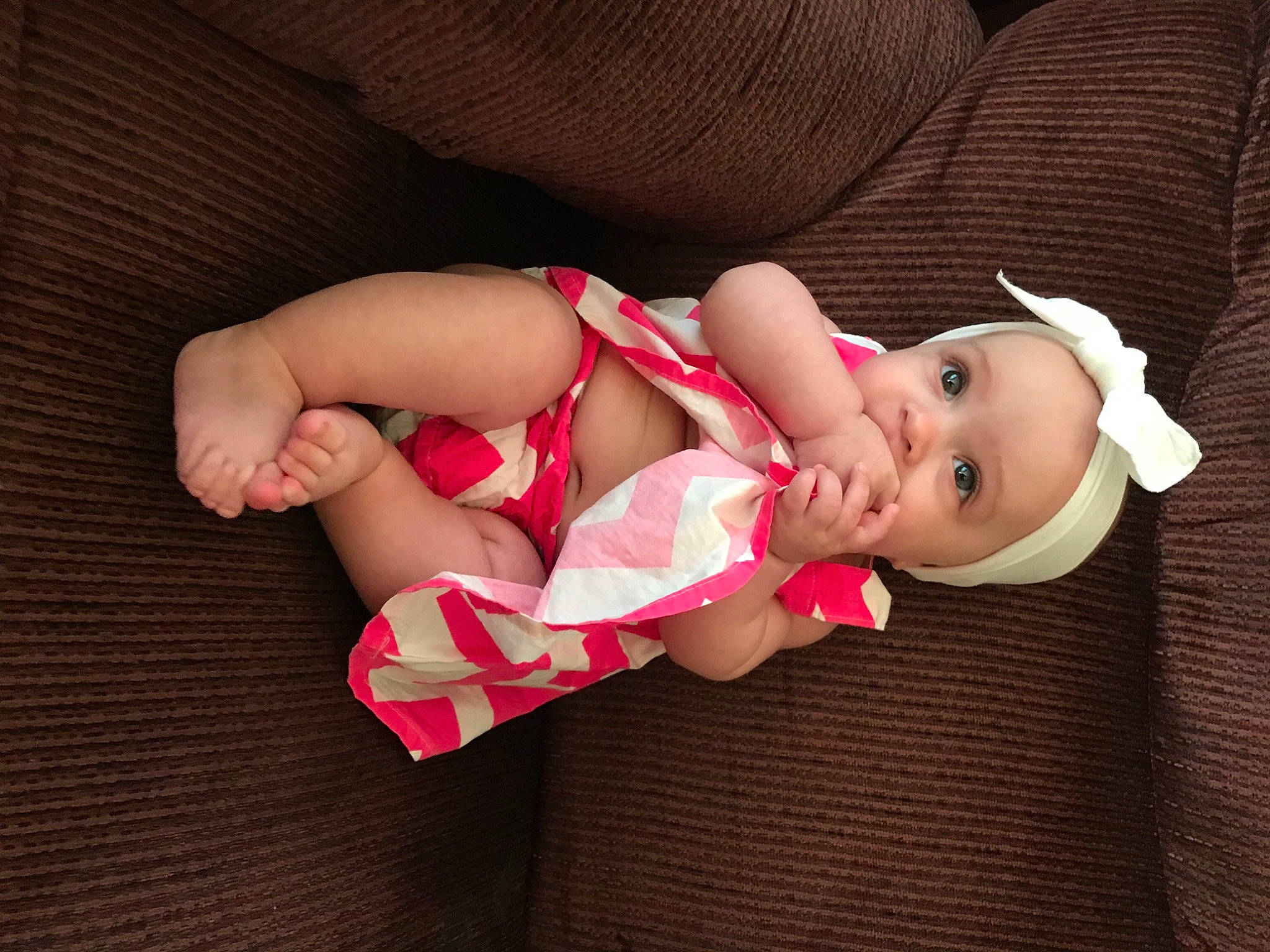 Laidan is registered to the contest to win money with this photo: baby, baby_toddler_clothing, cheek, comfort, eye, facial_expression, finger, foot, hand, head, headwear, human_body, human_leg, lip, person, pink, skin, sleeve, sock, textile