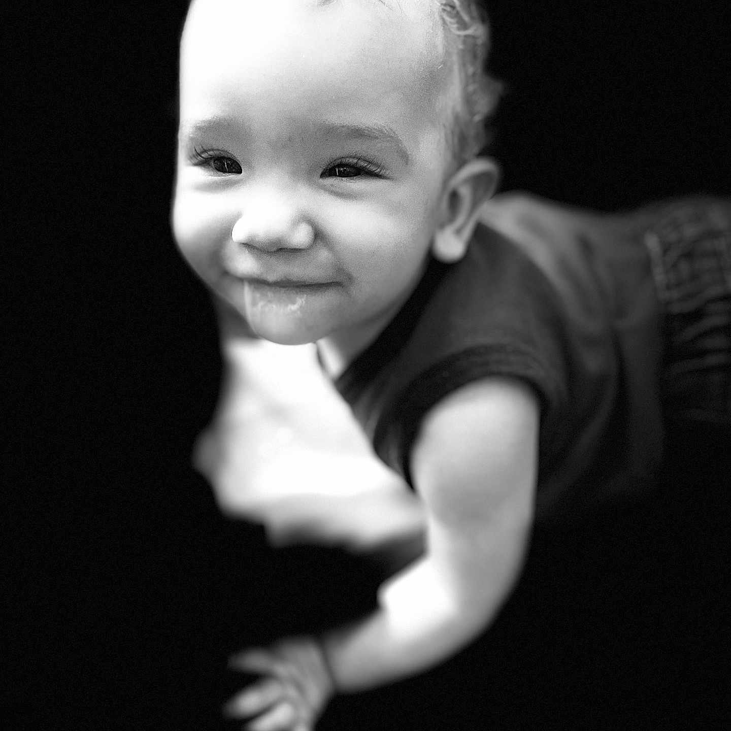 Deiondre joined the competition — help win amazing prizes! baby, child, crawling, smiling, black_and_white, portrait, face, infant, cute, happy, young, skin, hair, eyes, expression, hand, clothing, dark_background, closeup, person