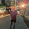 Gunnar joined the competition — help win amazing prizes! child, sparkler, night, outdoor, smile, happy, people, group, sidewalk, building, casual_clothing, shadow, light, celebration, fun, family, person, parking_lot, event, joy