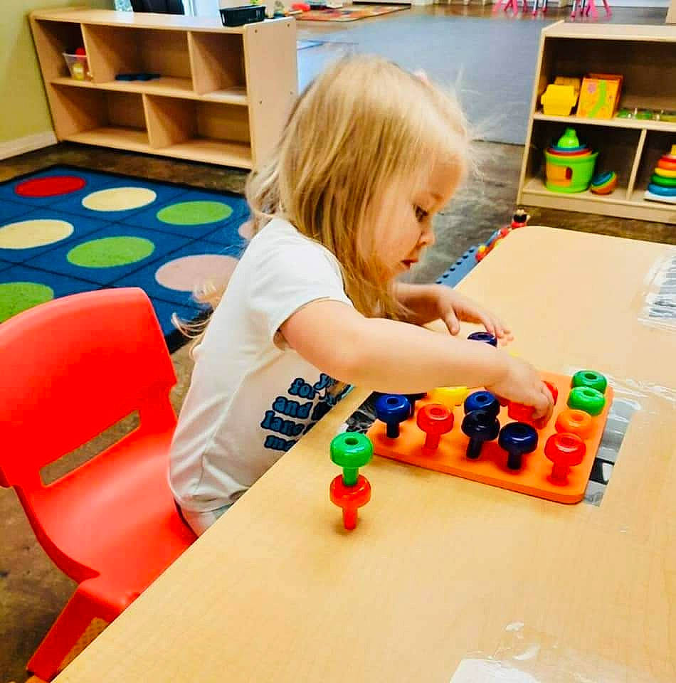 Kingsley is registered to the contest to win money with this photo: baby, bookcase, chair, child, flooring, fun, furniture, indoor_games_and_sports, leisure, nail, person, play, recreation, room, shelf, shelving, t_shirt, table, toddler, toy