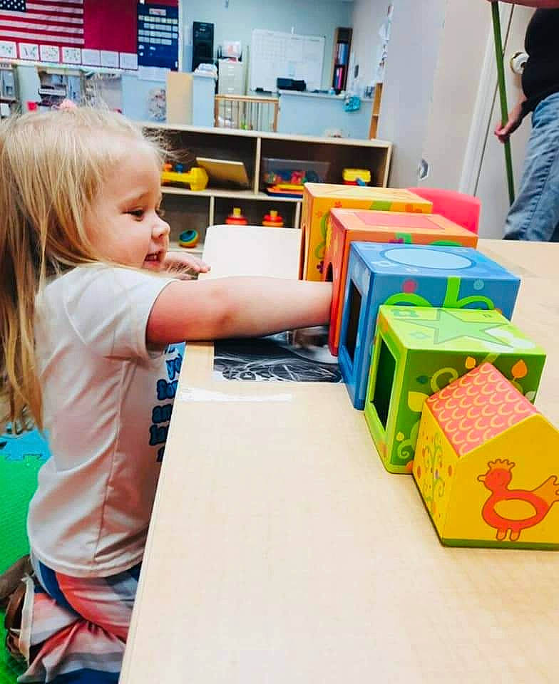 Kingsley is registered to the contest to win money with this photo: artist, box, child, customer, engineering, event, fun, learning, leisure, person, play, publication, recreation, room, sharing, shelf, shirt, t_shirt, table, toddler