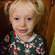 Athena participe au concours pour gagner de l'argent avec cette photo : child, girl, blonde_hair, pigtails, smile, sweater, candy_cane, snowflake, holiday_clothing, portrait, indoors, wooden_background, happy, cute, face, person, young_child, festive, christmas_theme, casual