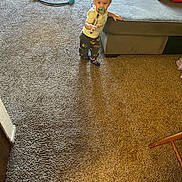 Jacob Corona is registered to the contest to win money with this photo: toddler, pacifier, child, carpet, living_room, sofa, baby_jumper, shoe, backpack, clothing, footwear, hand, person, indoor, furniture, balance, curious, standing, home, toy