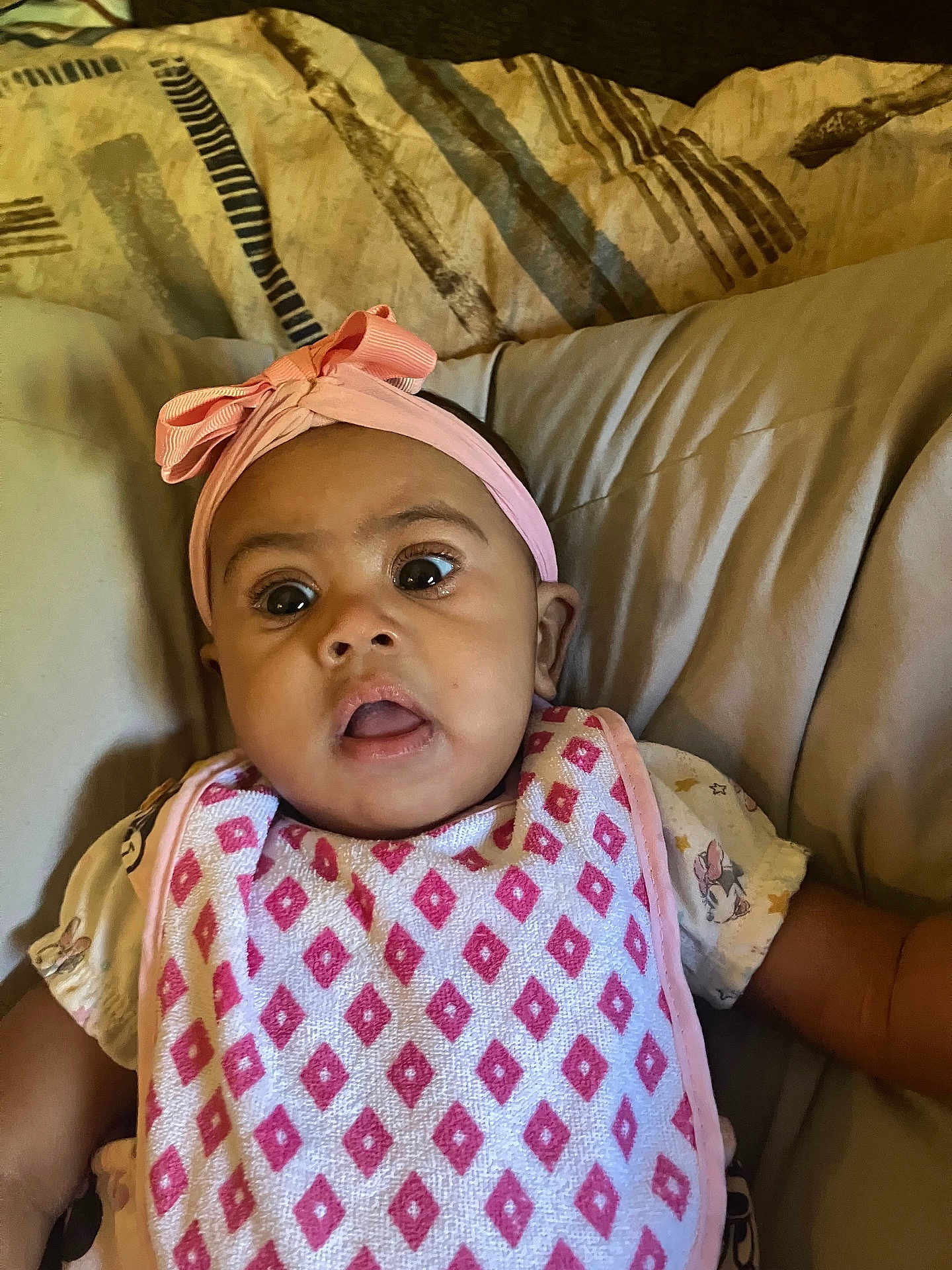 Kelisia joined the competition — help win amazing prizes! baby, infant, headband, pink, bib, pattern, face, eyes, mouth, expression, cushion, blanket, clothing, indoor, portrait, child, skin, person, cute, young