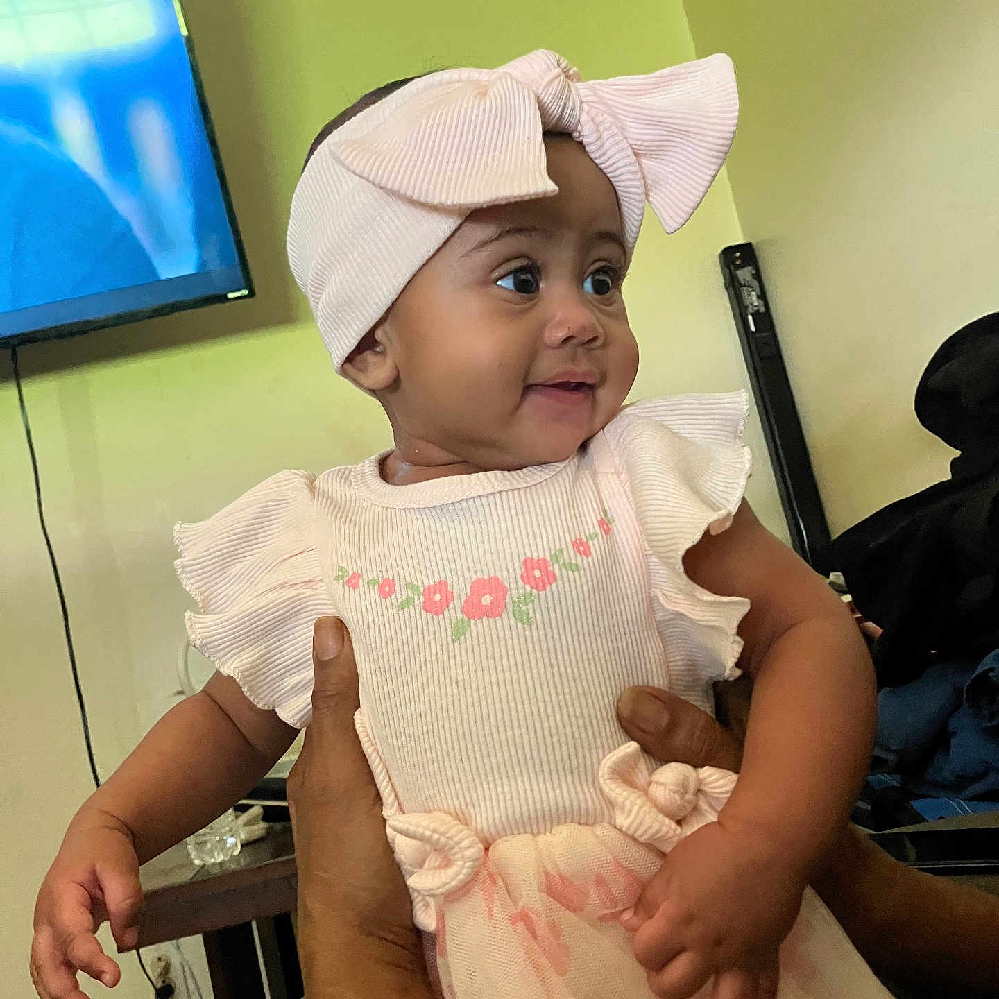 Kelisia joined the competition — help win amazing prizes! baby, bow, child, closeup, curious, cute, flower_pattern, hands, happy, headband, holding, indoor, infant, person, pink_dress, portrait, skin, smiling, tulle_skirt, young_child