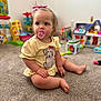 Navy joined the competition — help win amazing prizes! toddler, pacifier, hair_bow, yellow_shirt, carpet, indoor, toys, child, sitting, curious, plush_toy, colorful, playroom, baby, cute, expression, person, soft_light, floor, young_child