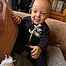 Kairo is registered to the contest to win money with this photo: baby, black_clothing, bookshelf, child, couch, cozy, decor, expression, face, furniture, hand, happy, head, home, indoors, pacifier, portrait, seated, smile, toy