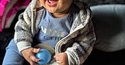 Kairo joined the competition — help win amazing prizes! baby, ball, blue_clothing, child, cozy, cute, face, focus, happy, indoor, infant, jacket, person, portrait, sitting, smiling, sock, soft, toy, young_child