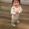 Elaina Amirah Beloua is registered to the contest to win money with this photo: child, toddler, pajamas, standing, smiling, video_call, man, floor, wooden_floor, indoor, hair_tie, happy, person, screen, technology, home, casual, cute, expression, communication