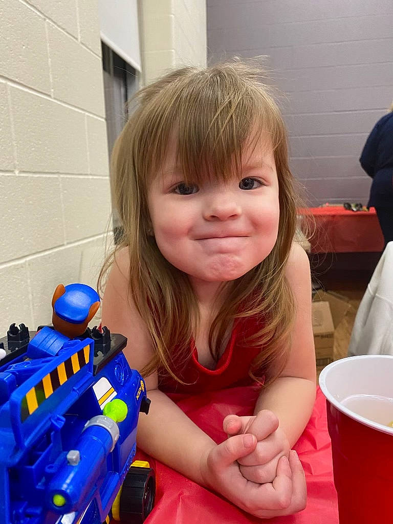 Kari joined the competition — help win amazing prizes! baby_toddler_clothing, bangs, chair, child, electric_blue, event, fictional_character, finger, fun, happy, joy, person, personal_protective_equipment, plastic, recreation, sitting, smile, t_shirt, thumb, toddler