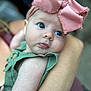 baby, infant, child, blue_eyes, pink_bow, headband, green_outfit, close_up, portrait, arm, holding, cute, skin, person, young_child, face, expression, soft_focus, outdoor, gentle