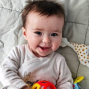Léna a rejoint le concours — aidez-le/la à gagner de superbes lots ! baby, child, smiling, toy, ball, giraffe_teether, blanket, clothing, infant, cute, happy, portrait, hand, face, indoors, soft_toys, playtime, toddler, young_child, casual