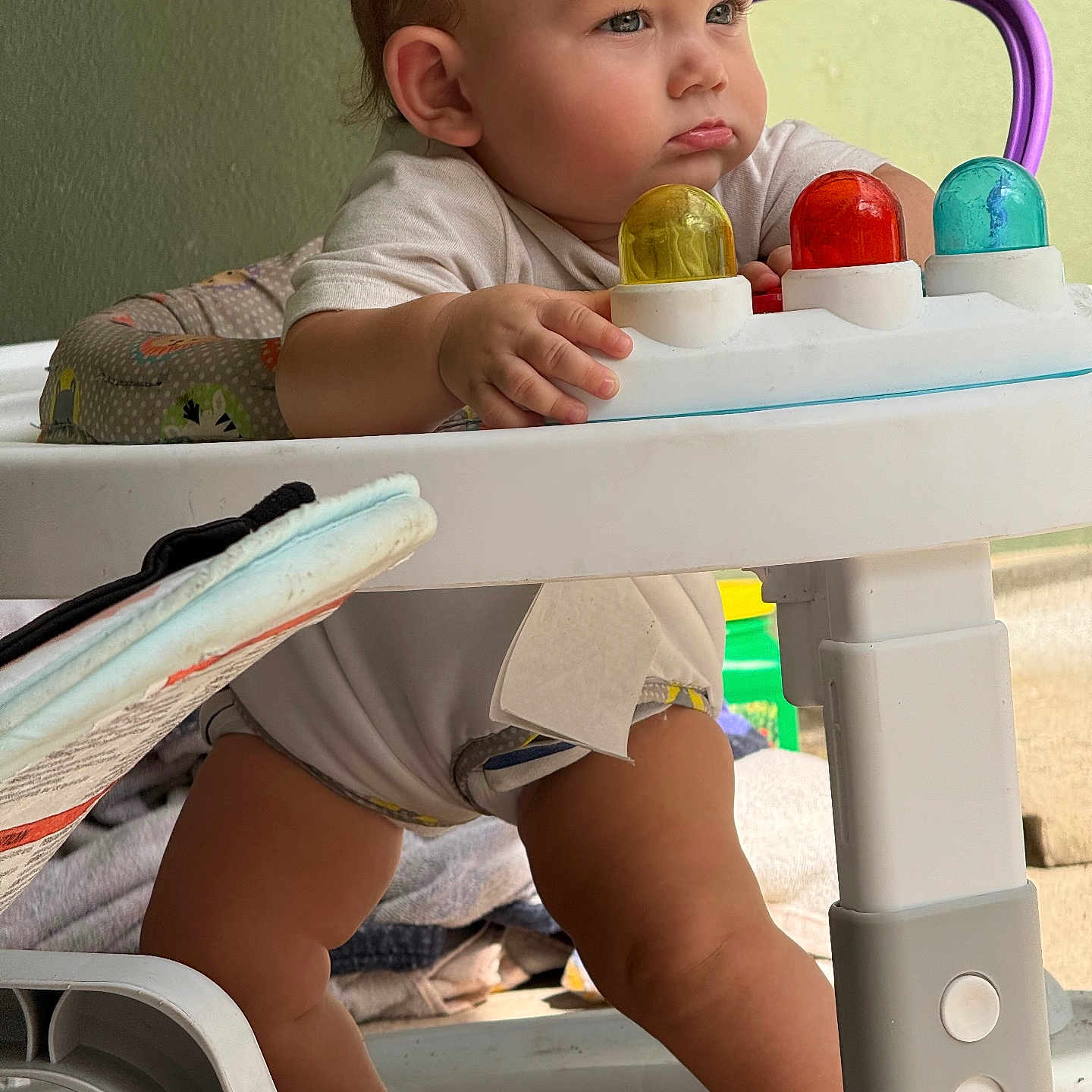 Praxton is registered to the contest to win money with this photo: baby, child, closeup, colorful, concentration, cute, expression, footwear, furniture, hand, home, indoor, infant, legs, plastic, playtime, toy, walker, white, young_child